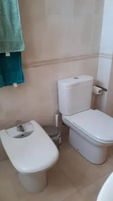 a white bathroom with a toilet and a sink at BRISA de MAR in Moncófar