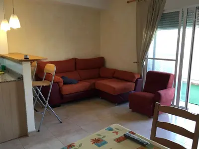 a living room with a red couch and a table at BRISA de MAR in Moncófar