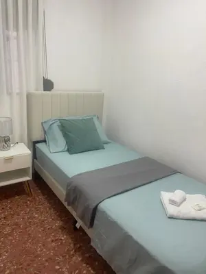 a bedroom with two twin beds and a night stand at Cataleya Apartment in Cullera