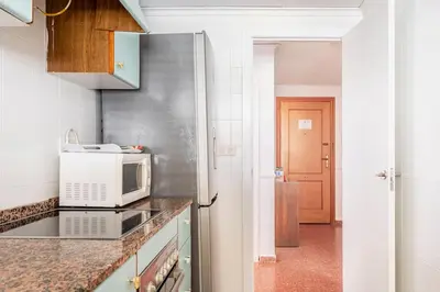 a kitchen with a microwave and a stove top oven at Villamar ,ACC, playa wifi y garaje in Cullera