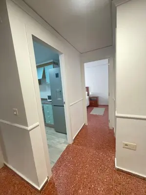 an empty room with a kitchen and a hallway at Villamar ,ACC, playa wifi y garaje in Cullera
