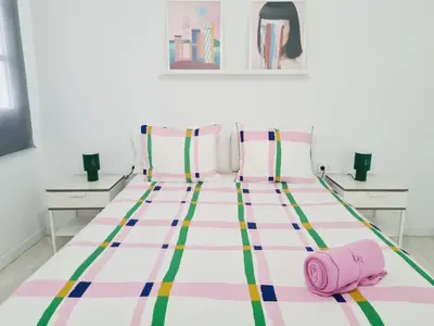 a bed with striped sheets and a pink towel on it at PATRAIX FLAT in Valencia