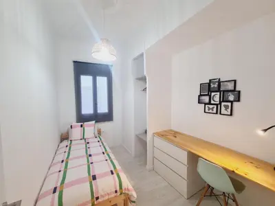 a bedroom with a bed and a desk in it at PATRAIX FLAT in Valencia