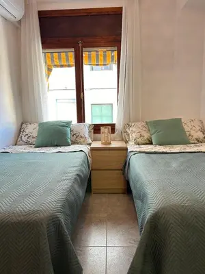 two beds sitting in a room with a window at Sea view apartment, first line on the beach, Remote work in Canet de Berenguer