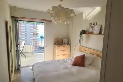 a bedroom with a bed and a large window at Piso nuevo y con vistas in Cullera