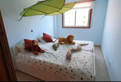 a bedroom with toy monkeys on a bed with a window at Piso nuevo y con vistas in Cullera