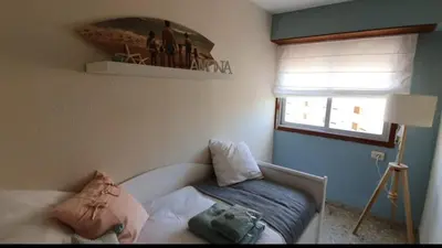 a bedroom with a bed and a window and a mirror at Piso nuevo y con vistas in Cullera