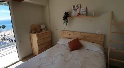 a bedroom with a bed and a large window at Piso nuevo y con vistas in Cullera