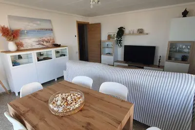 a living room with a table and a couch at Piso nuevo y con vistas in Cullera