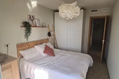 a bedroom with a white bed with a red pillow at Piso nuevo y con vistas in Cullera