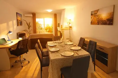 a living room with a table with chairs and a desk at Apartamento 1 linea mar terraza Port Saplaya in Port Saplaya