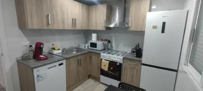 a small kitchen with wooden cabinets and a white refrigerator at Naquera House & Pool in Náquera