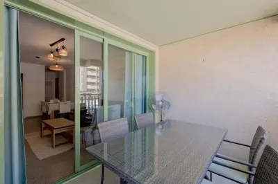 a dining room with a glass table and chairs at Apartamento playa Patacona con parking in Valencia
