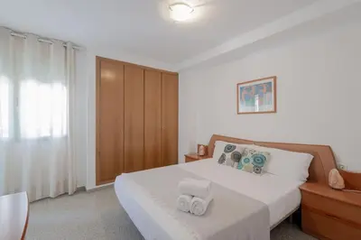 a bedroom with a bed with two towels on it at Apartamento playa Patacona con parking in Valencia