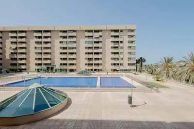 a swimming pool with a boat in front of a building at Apartamento playa Patacona con parking in Valencia