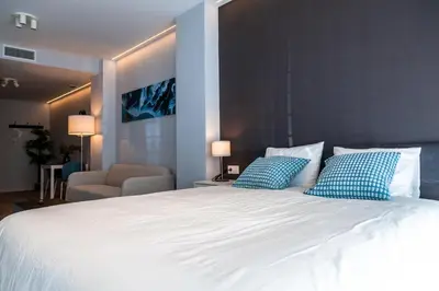 a bedroom with a large white bed with blue pillows at Mediterraneo Stay in Valencia