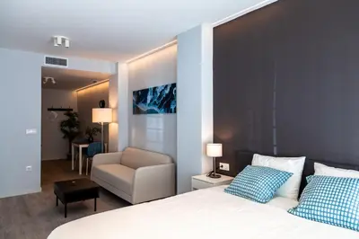 a bedroom with a bed with a chair and a couch at Mediterraneo Stay in Valencia