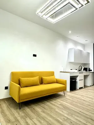 a yellow couch in a living room with a kitchen at Valencia Veneta Calda in Valencia