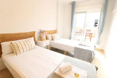a white room with two beds and a window at Maravilloso adosado para 8 en entorno privilegiado by Hometels in Canet de Berenguer