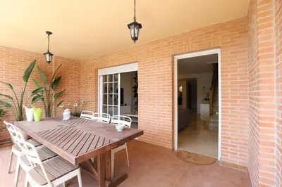 a dining room with a brick wall and a wooden table at Maravilloso adosado para 8 en entorno privilegiado by Hometels in Canet de Berenguer