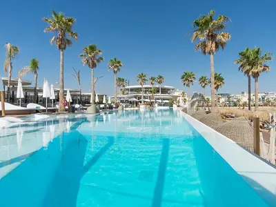 a large swimming pool with palm trees in a resort at Loft Industrial Doble Altura in Valencia