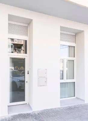 a white building with two windows and a door at Favara Suites B by Concept Flats in Valencia