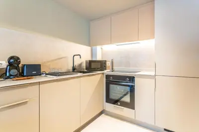 a kitchen with white cabinets and a stove top oven at Apartamentos 87 Llaves in Valencia
