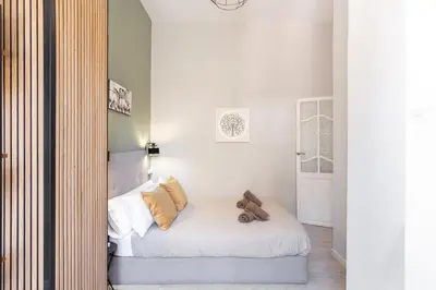 a bedroom with a bed with white sheets and pillows at at Maestro Gozalbo, Ruzafa in Valencia