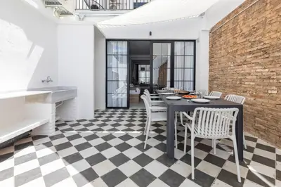 a dining room with a table and chairs on a checkered floor at My Loft 4 You Patraix Style in Valencia