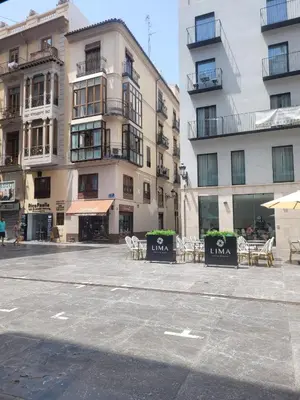 an empty street with tables and chairs in front of a building at Living Valencia Apartments - Merced in Valencia