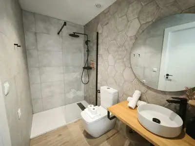 a bathroom with a toilet and a sink and a shower at FLORIT FLATS - Trafalgar Arts & Port Suites in Valencia