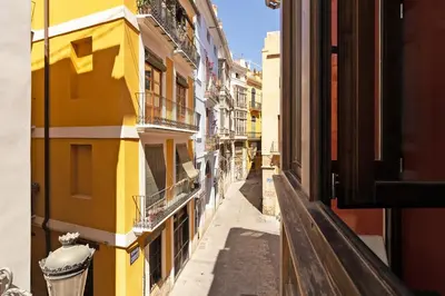 an alley in a city with yellow buildings at GuestReady - A perfect stay in Ciutat Vella in Valencia