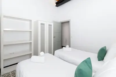 two twin beds in a room with white walls at GuestReady - A perfect stay in Ciutat Vella in Valencia