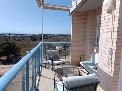 a balcony with two chairs and a view of a field at Beach,s House in Playa del Puig in La Torre