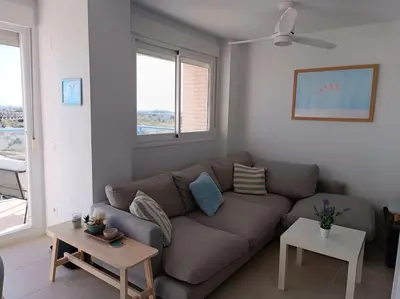a living room with a brown couch and two tables at Beach,s House in Playa del Puig in La Torre
