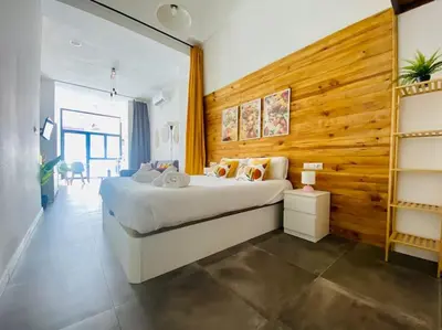 a bedroom with a large bed and a wooden wall at Beach Flat for Family & Groups in Valencia