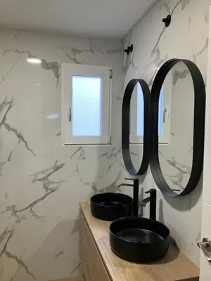 a bathroom with a sink and two mirrors on a counter at Mestalla Apartment Ideal for Mid-Term Stays in Valencia