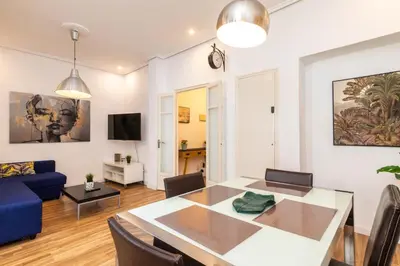 a living room with a table and a blue couch at Mestalla Apartment Ideal for Mid-Term Stays in Valencia