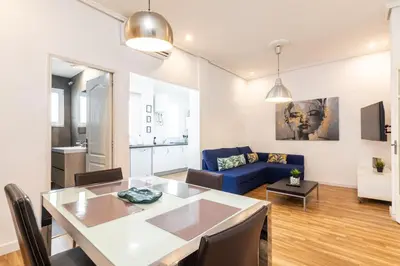 a living room with a table and a blue couch at Mestalla Apartment Ideal for Mid-Term Stays in Valencia