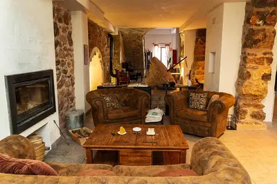a living room with couches and a table at Masia de Matuta in Vall de Almonacid