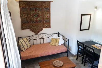 a bed in a room with a table and a desk at Masia de Matuta in Vall de Almonacid