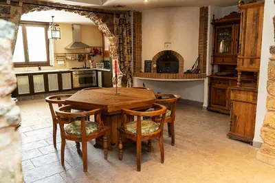 a kitchen with a wooden table and some chairs at Masia de Matuta in Vall de Almonacid