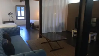 a living room with a couch and a mirror at Loft en molino rehabilitado in Paterna