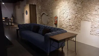 a living room with a blue couch and a table at Loft en molino rehabilitado in Paterna