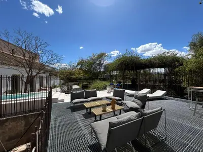 a patio with couches and a table and a fence at Loft en molino rehabilitado in Paterna