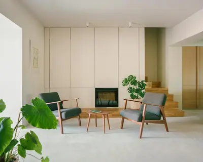 a living room with two chairs and a table and a fireplace at La Casa del Mar in Valencia