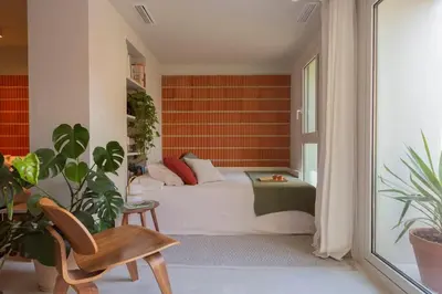 a bedroom with a bed and a chair and plants at La Casa del Mar in Valencia