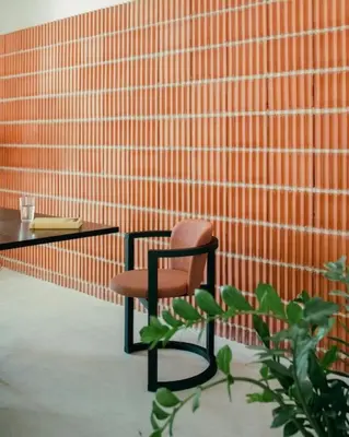 a chair sitting next to a table and a plant at La Casa del Mar in Valencia