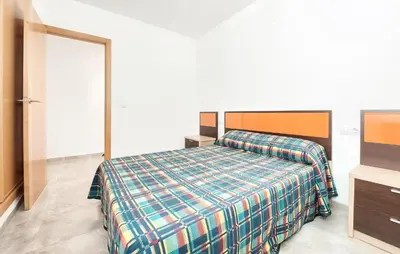 a bedroom with a bed with a plaid blanket at 2 Bedroom Amazing Apartment In Moncofa in Moncófar