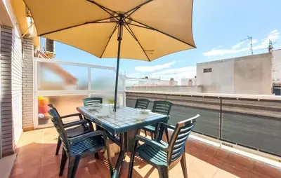 a table with chairs and an umbrella on a balcony at 2 Bedroom Amazing Apartment In Moncofa in Moncófar